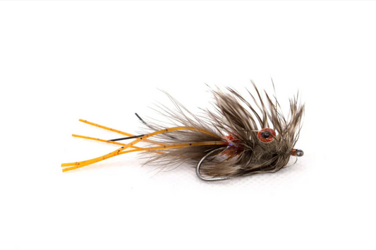 Fishing fly with brown feathers and orange legs on a white background. perfect for redfish