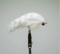 Load image into Gallery viewer, Fishing fly with white and yellow feathers on a gray background. rabbits foot white