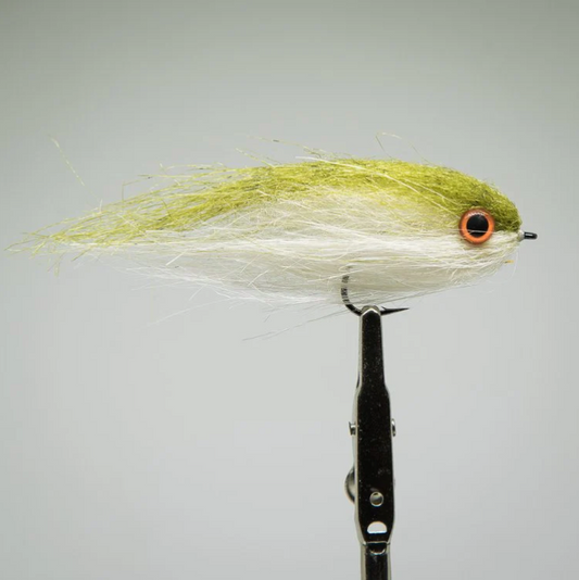 Fly fishing lure with green and white body on a gray background. brush head minnow